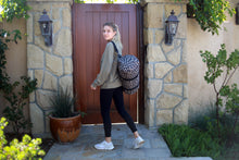 Load image into Gallery viewer, Female model standing with Cheetah Print duffel bag hanging over her shoulder with shoulder strap
